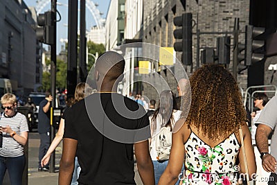 London, U.K., August 22, 2019 - cheerful young afro american couple walking on urban street in london. Editorial Stock Photo