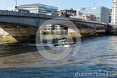 LONDON, UK - APRIL 1, 2019: The Marine Police Force Thames River Police, Patrolling under London Bridge Editorial Stock Photo