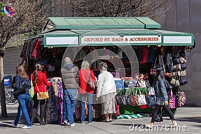 Tourist buying a souvenir gift at a street market stall selling leather handbags Editorial Stock Photo