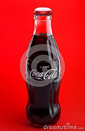 LONDON, UK -DECEMBER 07, 2017: Bottle of Classic Coca-Cola on red. Coca-Cola is one of the most popular soda products in the world Editorial Stock Photo