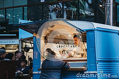 Woman buying food from Sud Italia pizza stall inside Spitalfields Market, London, UK Editorial Stock Photo