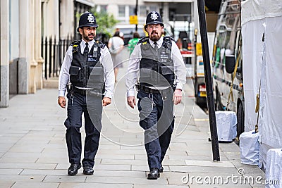 London, UK, July, 2019. Two British Police officers patrolling the streets of England wearing stab vests. Oxford Street Editorial Stock Photo