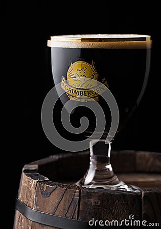 LONDON, UK - MAY 03, 2018: Cold Glass of Grimbergen dubbel beer on wooden barrel. Editorial Stock Photo
