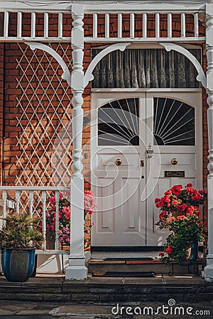 White stained glass front door of Edwardian house in London, UK, sunlight hits brick wall Editorial Stock Photo