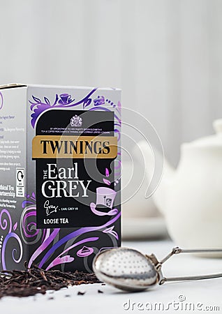 LONDON, UK - OCTOBER 21, 2020: Box of Twinings Earl Grey loose tea with ceramic teapot and vintage strainer infuser on white Editorial Stock Photo