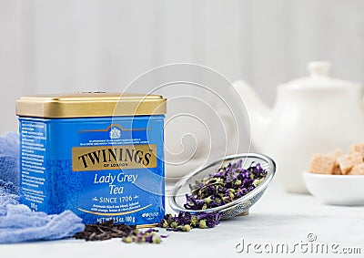 LONDON, UK - OCTOBER 21, 2020: Steel jar of Twinings Lady Grey loose tea with ceramic teapot and cane sugar on white Editorial Stock Photo