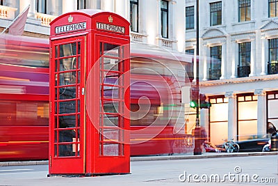 London, UK. Red telephone booth and red bus passing. Symbols of England. Stock Photo