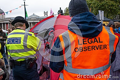 Police officer monitoring Extinction Rebellion protesters at Trafalgar Square London UK. Editorial Stock Photo