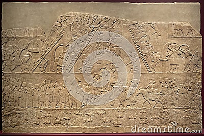 London, United Kingdom - Ancient Assyria clay tablet relief of Assyrian army soldiers invading Egypt from king Ashurbanipal royal Editorial Stock Photo