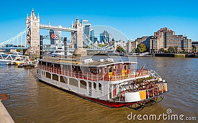 Tower bridge over Thames river on a sunny day with wharf and boats. City Financial Editorial Stock Photo