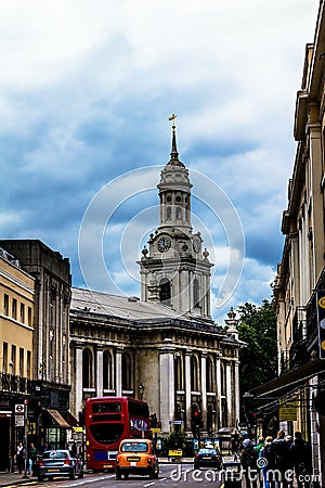 Clock tower of St Alfege Parish church, Royal Borough of Greenwich in London behind a common houses. Editorial Stock Photo