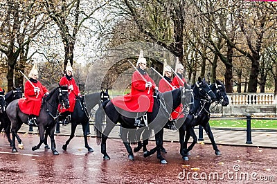 London, United Kingdom - 11/04/2016: Parade Royal Guard on black horses on street in London, after rain, in the background a bit b Editorial Stock Photo