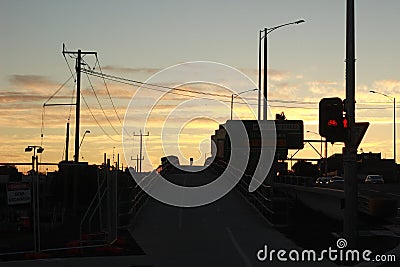 Lone bicycle cyclist riding across a city bridge on a summer day after work riding into the sunset, Melbourne city, Victoria, Stock Photo