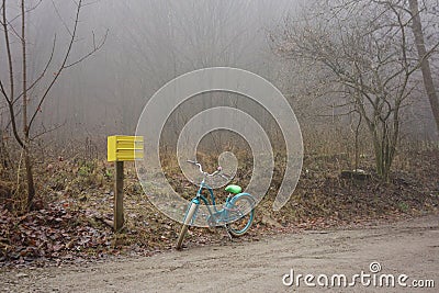 Lone bicycle next to a yellow mailbox Stock Photo