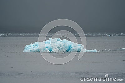 A lone blue iceberg from a glacier sits in Resurrection Bay Stock Photo