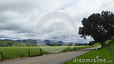 Lone cyclist on country road in valley around Santa Maria California Editorial Stock Photo
