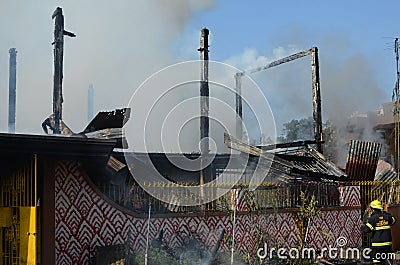 Lone fireman attempting to enter the premises of a burning house Stock Photo