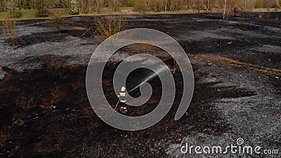 Lone fireman extinguishing the remains of a wildfire in natural reserve Biebrza in Poland Stock Photo