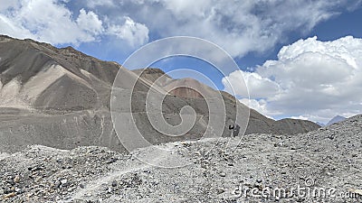 A lone hiker walks along a mountain path. View of the mountains, colored rocks and hills of Kyrgyzstan. Beautiful mountain Editorial Stock Photo