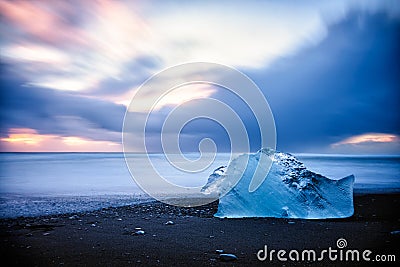 Lone iceberg melting by the ocean Stock Photo