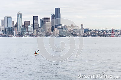 A lone kayaker paddles toward the Seattle skyline. Stock Photo