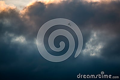 A Lone Kite Flying among Dark Clouds in Stormy Sky Stock Photo