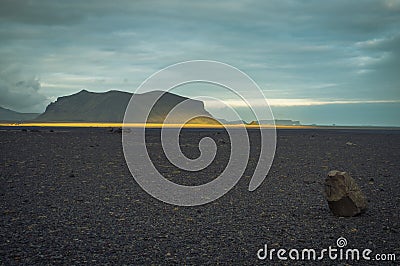 A lone mid size piece of rock on a flat land Stock Photo