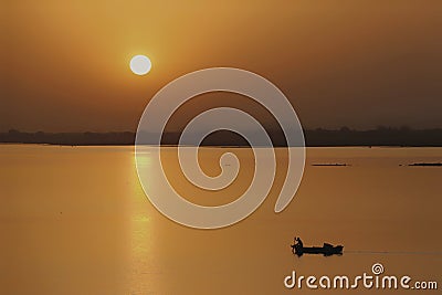 A Lone Rider on his boat heading towards home after his daily fishing Stock Photo