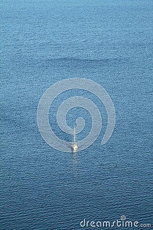 A lone sailboat in the deep blue Aegean Sea. Aerial shot. Stock Photo