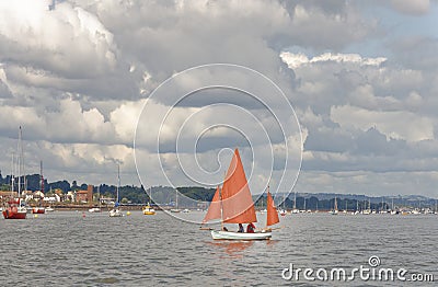 Starcross, devon: sailing boat with dark orange sails Editorial Stock Photo