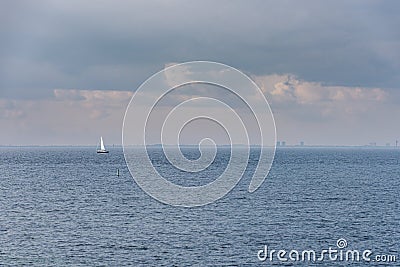 A lone sailing boat at sea in the Oresund Strait suggests relaxation. Sailboat in the ocean conveys tranquillity and serenity Stock Photo