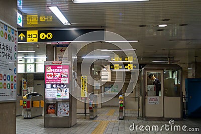 A lone train station master standing inside a booth in an Osaka metro train station Editorial Stock Photo