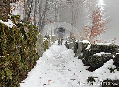Lone walker in the mountain path with snow Stock Photo