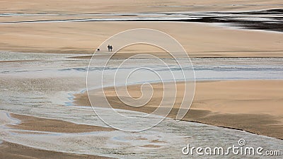 Lone Walkers with dog on Crantock Beach, Cornwall Stock Photo