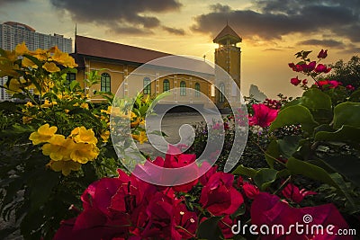 A Lone Wooden Church at Dusk with Sunset Clouds and beautiful flowers in the foreground Stock Photo