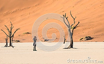 Lonely adventure travel photographer at Deadvlei crater in Sossusvlei Stock Photo