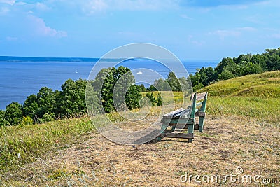 A lonely bench on a mountain with a beautiful view of the Volga River. A place for solitude, meditation, rethinking the meaning of Stock Photo