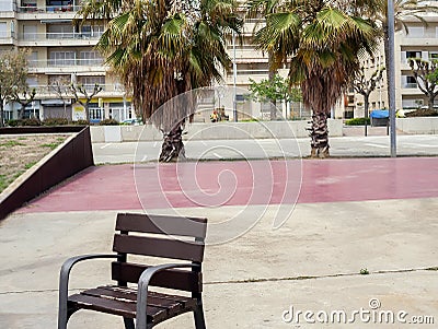 Lonely painted bench on the playground, against the background of two palm trees Stock Photo