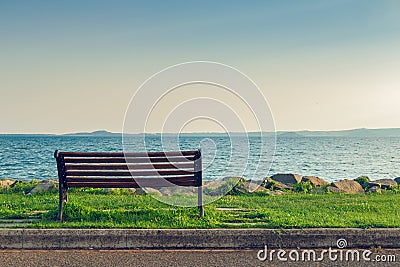 Lonely bench on sea coast Stock Photo