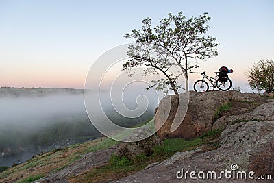 Bicycle over misty canyon, river and stones Stock Photo