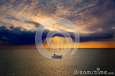 Lonely boat lit by divine light from cloud Stock Photo