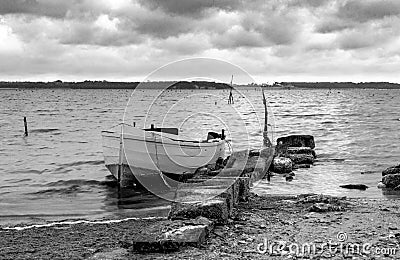 Lonely boat at quay. Sunset scenic landscape. black and white Stock Photo