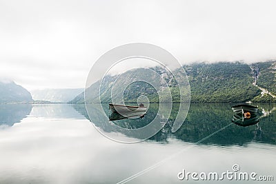 lonely boats calm lake with misty mountain background. High quality photo Stock Photo
