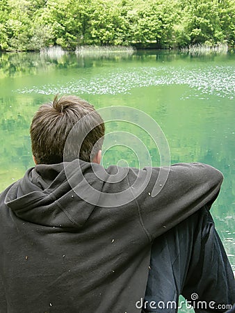 Lonely boy on green river Stock Photo