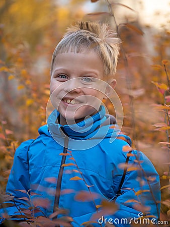 Lonely boy with a smile in autumn Park Stock Photo