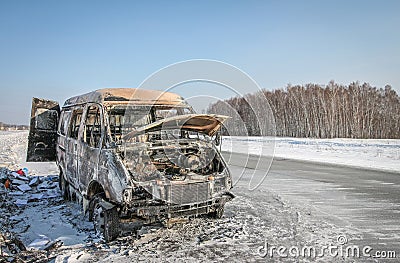Lonely burnt car on a suburban highway Stock Photo
