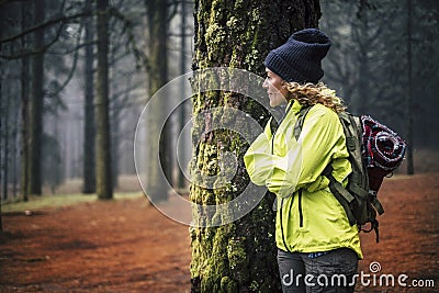 Lonely caucasian middle age woman standing in the forest and look the beautiful wood around her - concept of alternative trekking Stock Photo