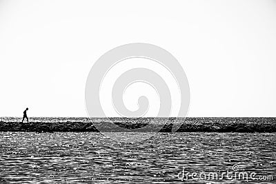 Lonely child walks on a thin coastline. Editorial Stock Photo