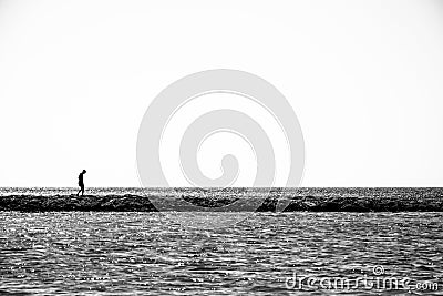 Lonely child walks on a thin coastline. Editorial Stock Photo