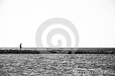 Lonely child walks on a thin coastline. Editorial Stock Photo